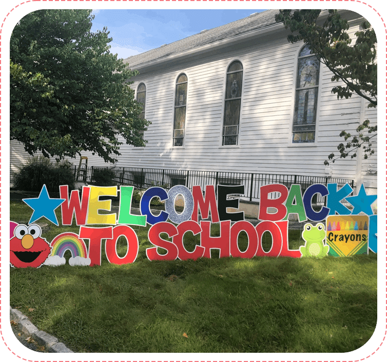 A yard sign that says welcome back to school.